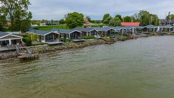 A row of modern waterfront cabins with outdoor decks and a dock.