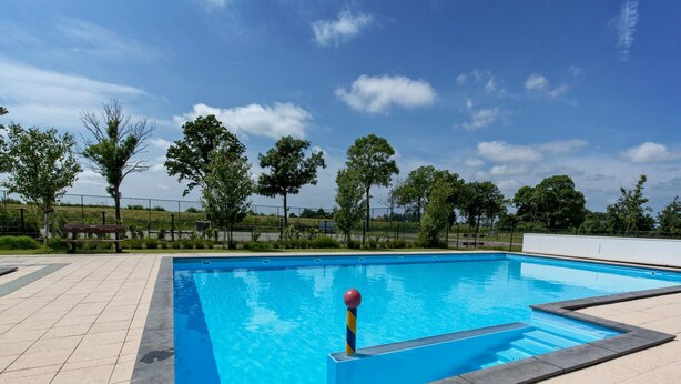 A rectangular swimming pool with a blue water surface, surrounded by a tiled deck. - Dutch Family Geataway in West-graftdijk (West-Graftdijk)