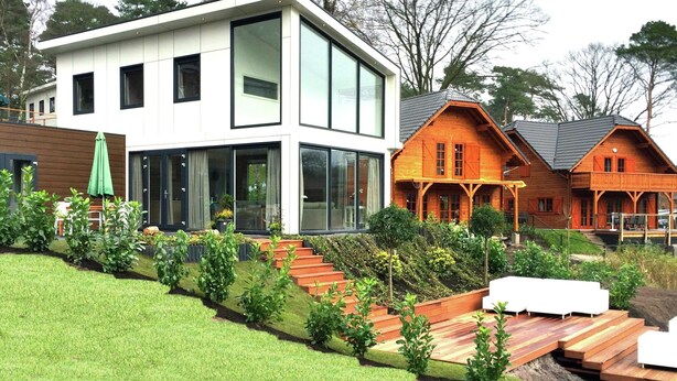 A modern two-story house with large windows and a wooden deck. - Modern Holiday Home Near Brunssummerheide (Brunssum)