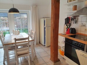 A kitchen with a dining area, a refrigerator, and a stove.