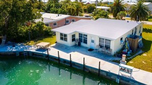 A modern two-story house with a large deck and a swimming pool. - Fish Camp | Old Florida canalfront getaway (Key West)