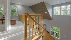 A spacious loft with a wooden staircase, large windows, and a sloped ceiling. - Retreat 52 - Family retreat / Innsbruck GolfResort (Helen)