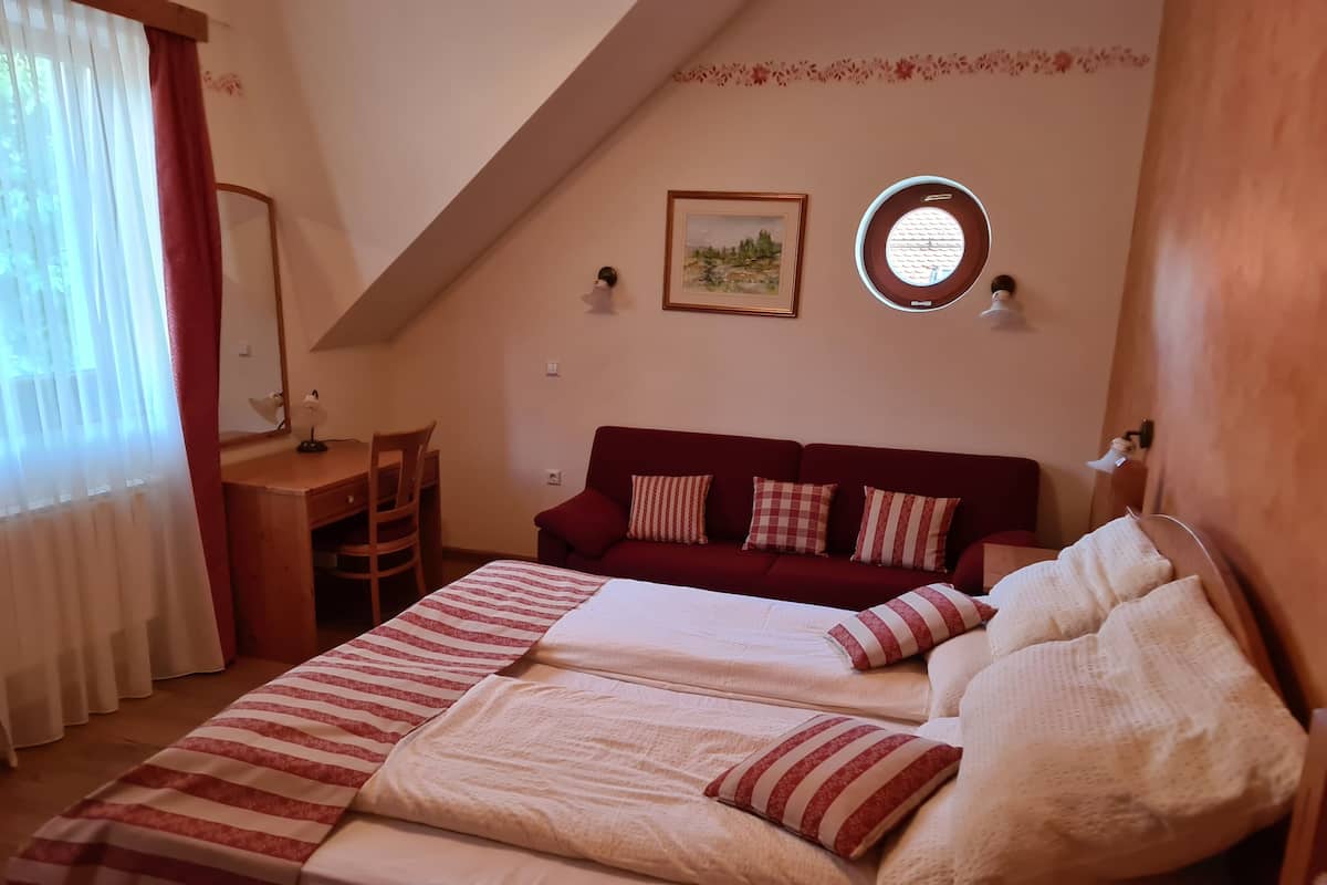 Une chambre confortable avec deux lits, un bureau et une fenêtre avec des rideaux.