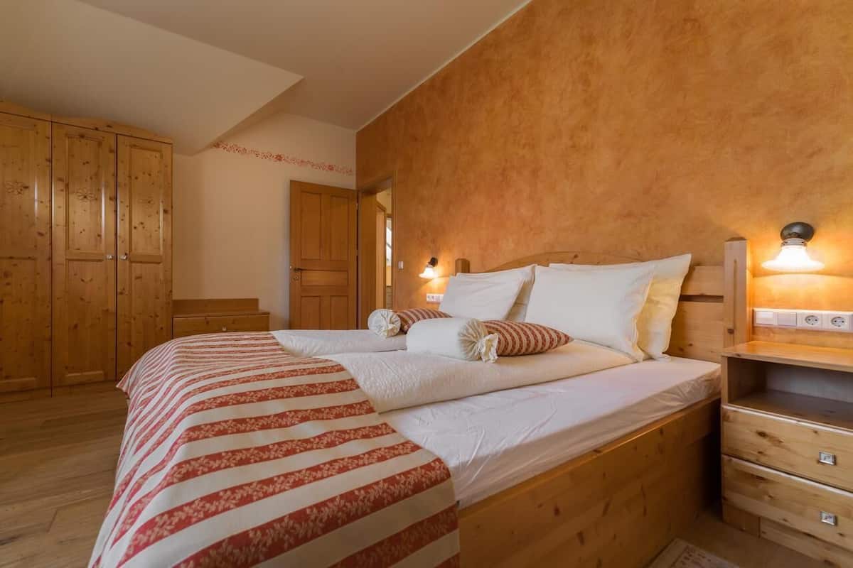 Une chambre à coucher en bois, avec un lit, des tables de chevet et une armoire.