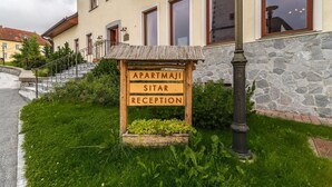 A reception sign for an apartment building with a stone facade and wooden accents. - Apartments Sitar (Ribnica na Pohorju)