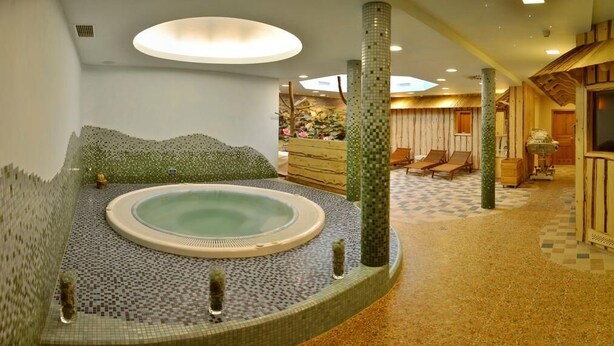 A spa area with a hot tub, wooden sauna, and seating area. - Apartments Sitar (Ribnica na Pohorju)