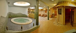A spa area with a hot tub, wooden sauna, and seating area. - Apartments Sitar (Ribnica na Pohorju)
