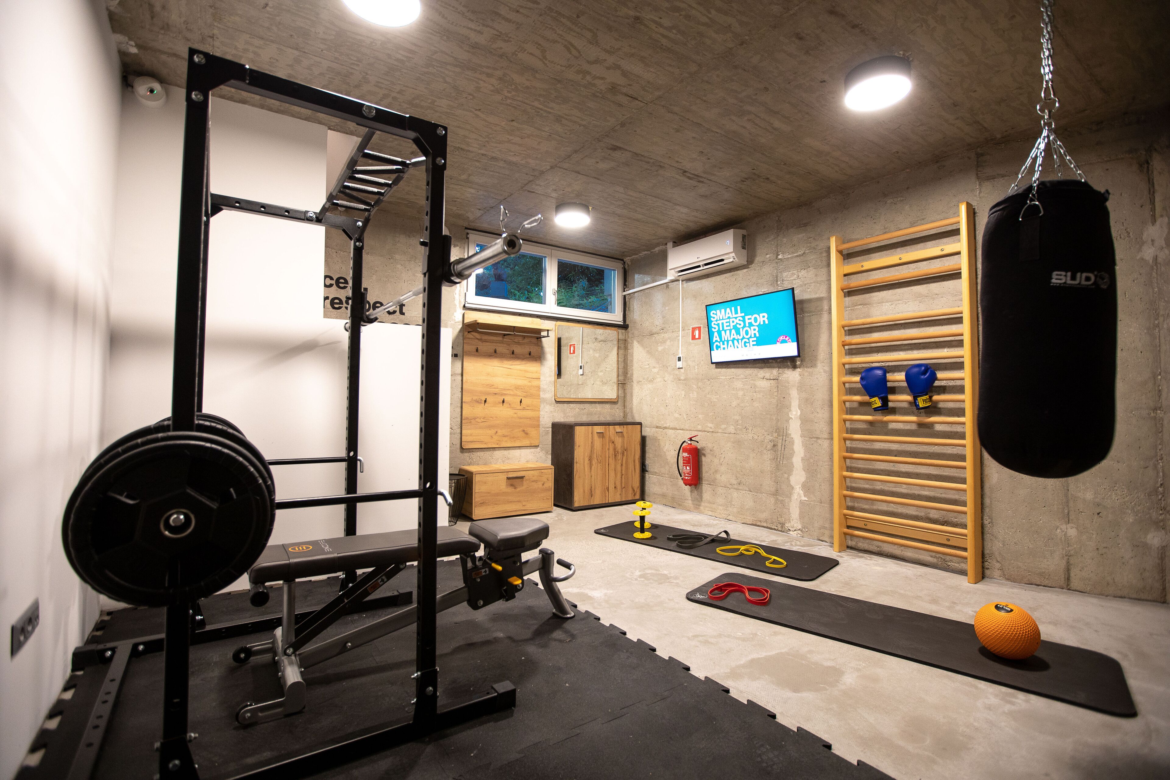 A gym with a squat rack, weight bench, and various exercise mats.