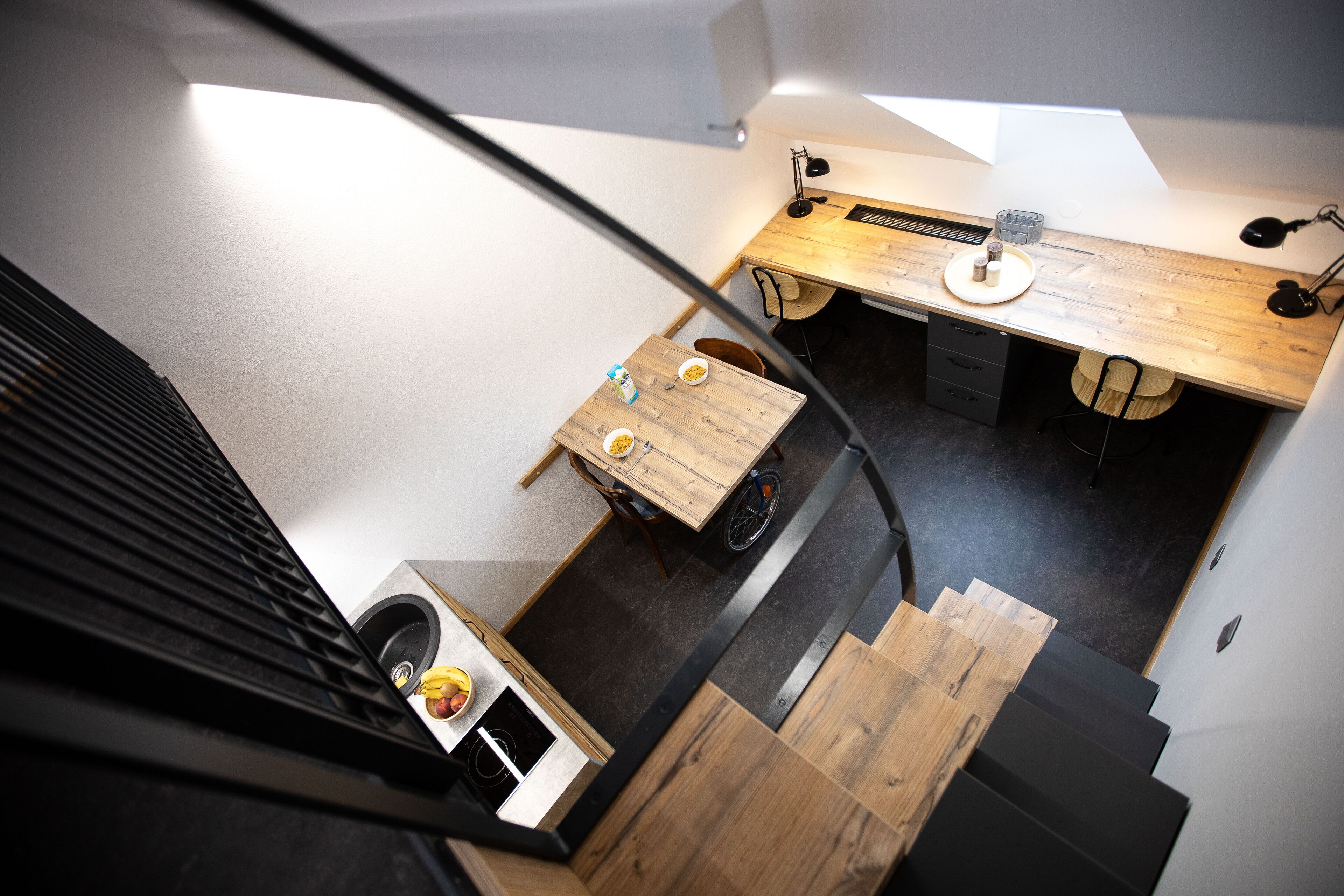 Una cocina moderna con encimera de madera, una pequeña mesa de comedor y una silla accesible para personas en silla de ruedas.