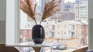 A modern room with a large window, a vase with dried plants, and two chairs. - Abode Philadelphia - Center City Convention Center (Philadelphia)