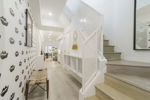 Una scala con ringhiere bianche e finitura in legno, che conduce a un piano superiore.