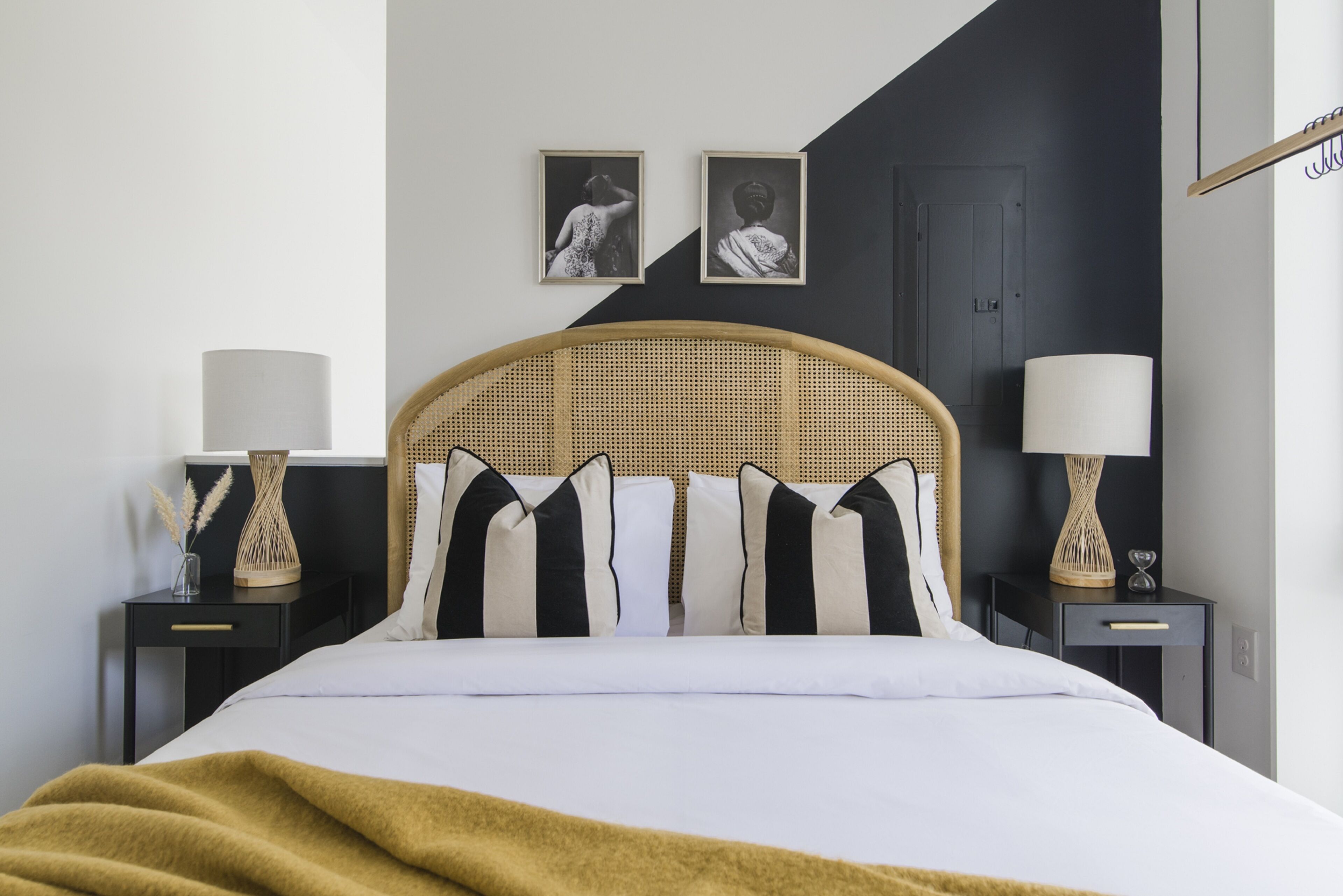Een netjes ingerichte slaapkamer met een bed, twee nachtkastjes en twee wandlampen.