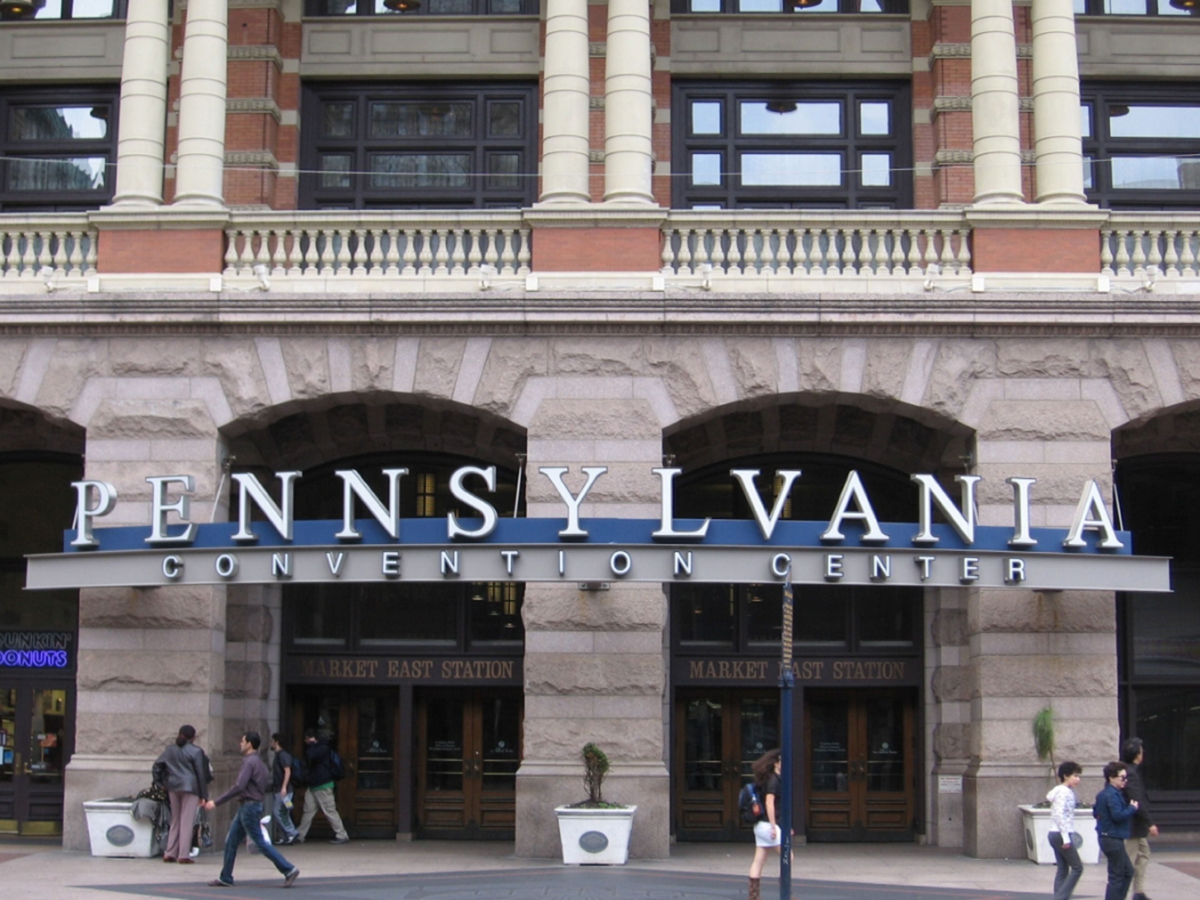 The Pennsylvania Convention Center entrance with people walking in front.