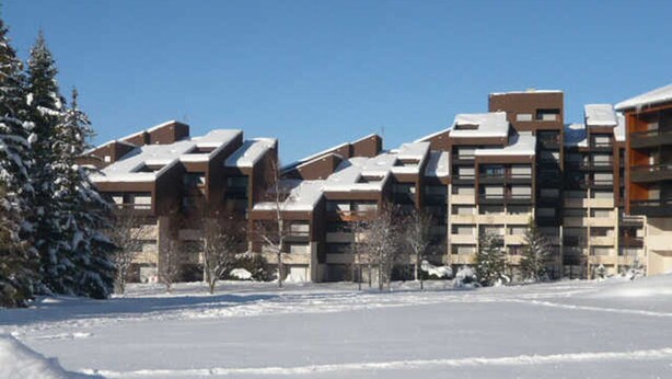 Un quartier résidentiel enneigé, avec des immeubles d’appartements modernes.