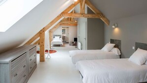 Quarto com duas camas, uma escrivaninha e vista para o banheiro e cozinha.