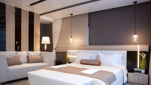 A modern hotel room with a large bed, a sofa, and a nightstand with a lamp. - Family Hotel Business Club (Shumen)