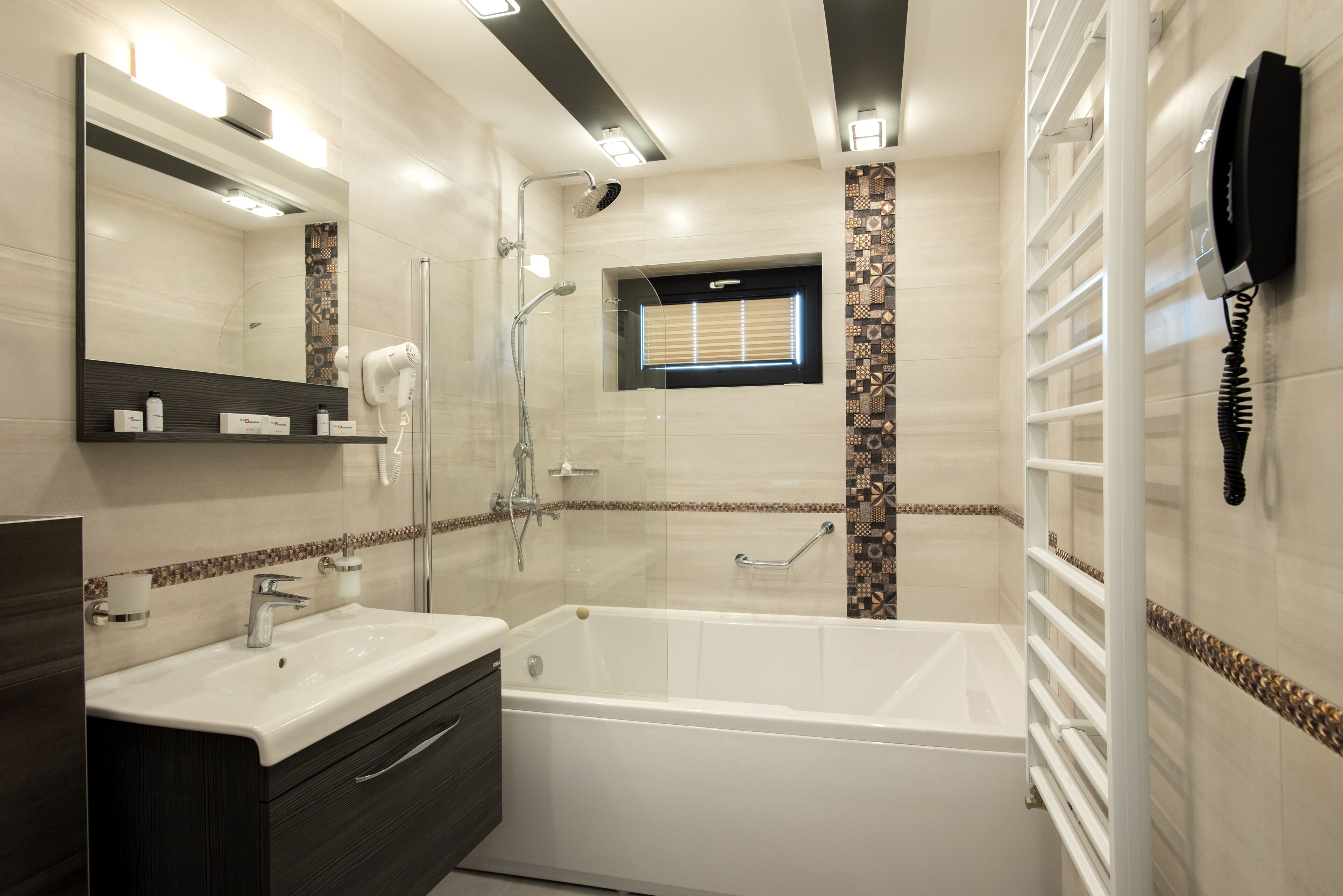 Une salle de bain moderne dotée d’une grande baignoire, d’un meuble-lavabo avec miroir et d’un espace douche.
