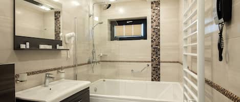 Uma casa de banho moderna com uma banheira grande, uma toucador com espelho e uma área de duche.