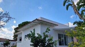 A modern white house with a tiled roof, a small garden, and a tree in the foreground. - Villa Flavia, Mediterranean charm. Apartment, private pool at100 mt sea (Fontane Bianche)