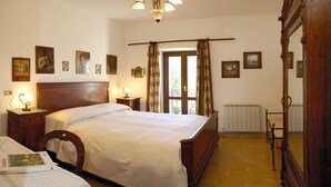 Un dormitorio con una cama de madera, mesitas de noche, un espejo y cuadros en las paredes.