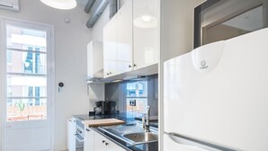 Eine moderne Küche mit weißen Schränken, einer schwarzen Arbeitsplatte und Edelstahlgeräten.