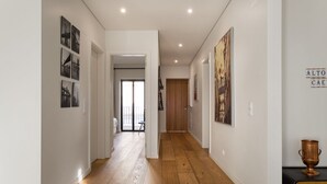 A hallway with wooden flooring, white walls, and a staircase leading to another room. - JOIVY Spacious flat in Bairro Alto (Lisboa)