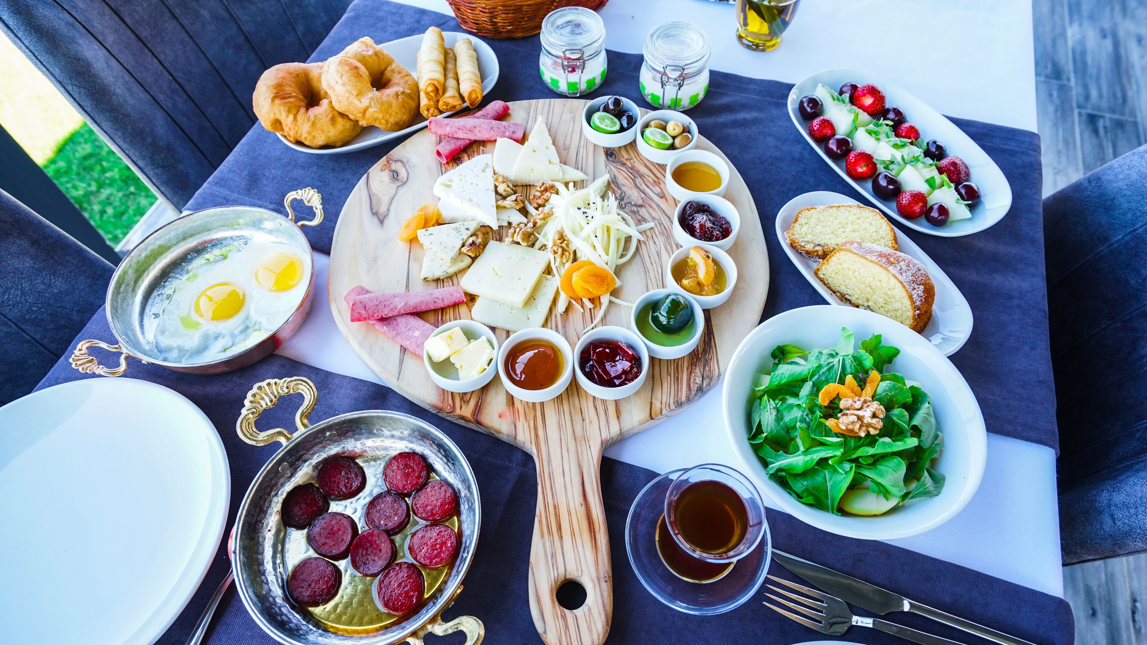 A table set with various foods including cheese, fruits, and nuts, suggesting a meal or buffet setup.