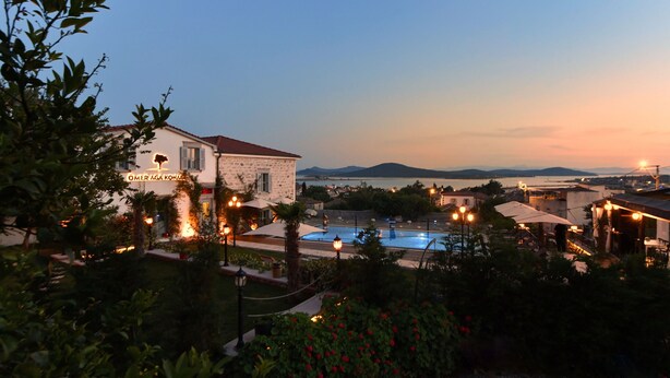 A hotel with a pool, surrounded by greenery and a view of the sea. - Omer Aga Konagi (Ayvalik)