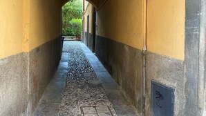 Un pasillo con paredes amarillas, suelo de piedra y techo abovedado.