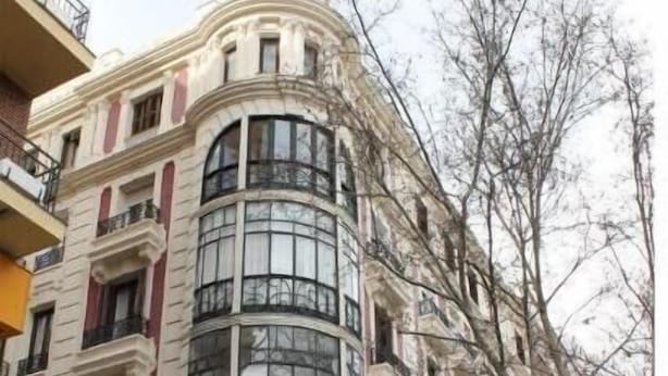 Un edificio en esquina con un escaparate que dice 'Santander'.