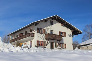 Un immeuble à plusieurs étages doté de balcons, entouré de neige.