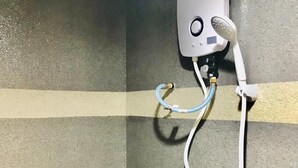 A shower with a handheld showerhead mounted on the wall, a handheld shower attachment, and a shower control panel. - Highway Times Inn (Ipoh)