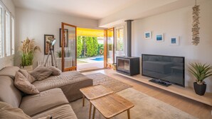 Een moderne woonkamer met een bank, televisie en een open haard.