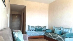 Ein modernes Wohnzimmer mit einer Couch und einer Liegesofa, beide mit blauen Kissen.