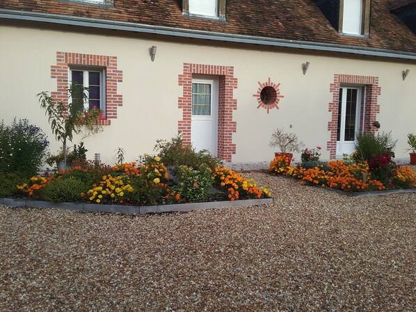 A house with a beige exterior, red brick accents, and a gravel driveway. - La Halte de Chambord (Mur-de-Sologne)