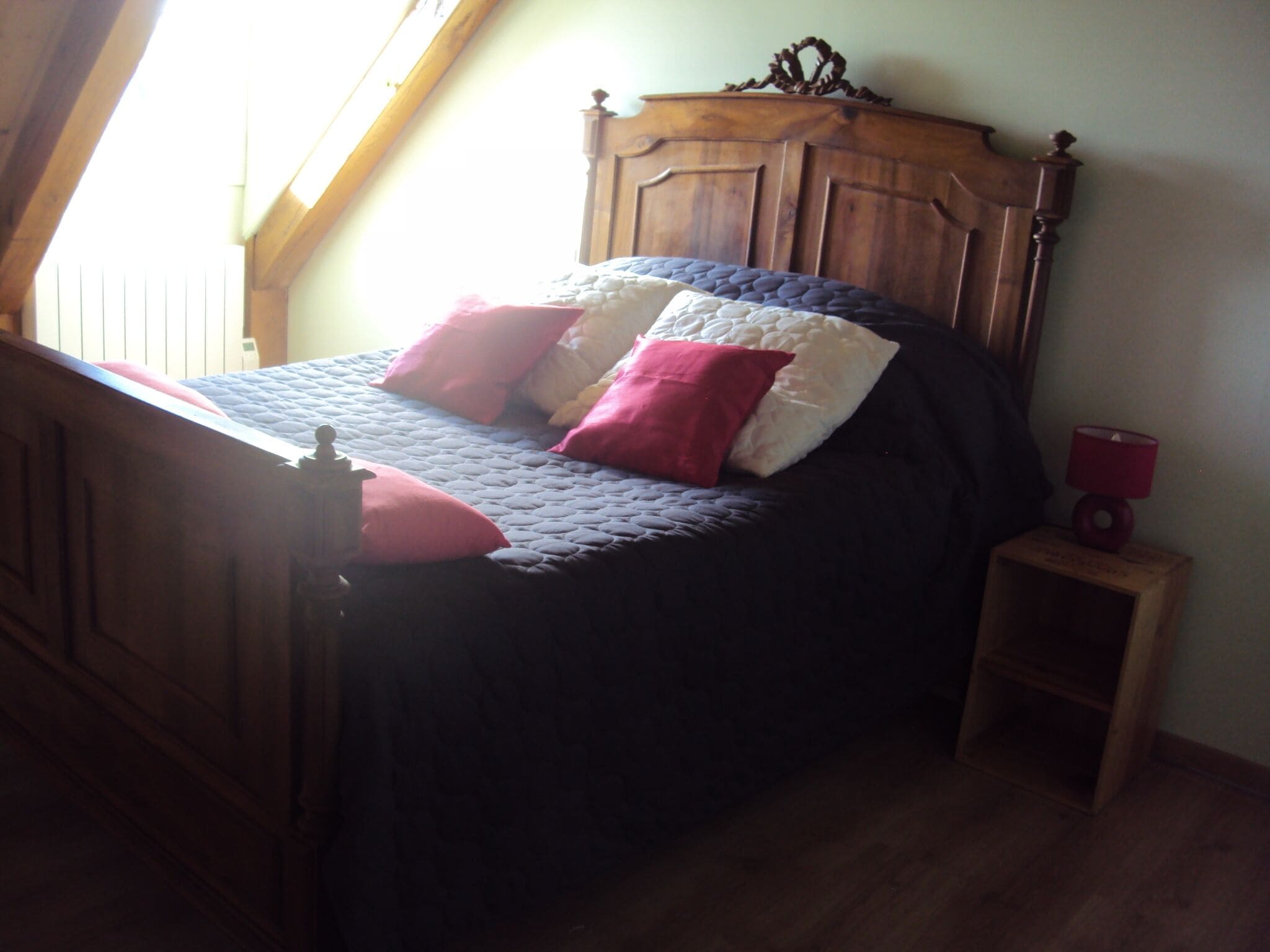 Ein Schlafzimmer mit einem Bettgestell aus Holz, einer gesteppten Bettdecke und zwei Nachttischen.