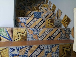 Stunning staircase features intricately patterned tiles with geometric and floral designs.