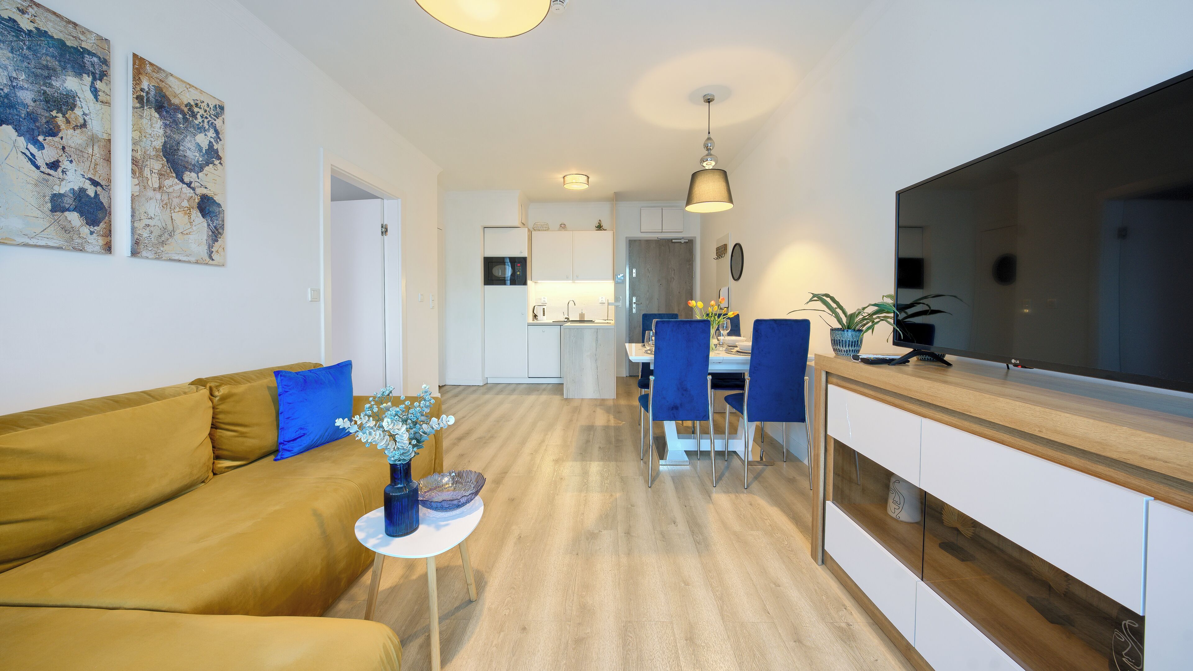 A modern living room with a sofa, a coffee table, and a dining area with chairs and a table.