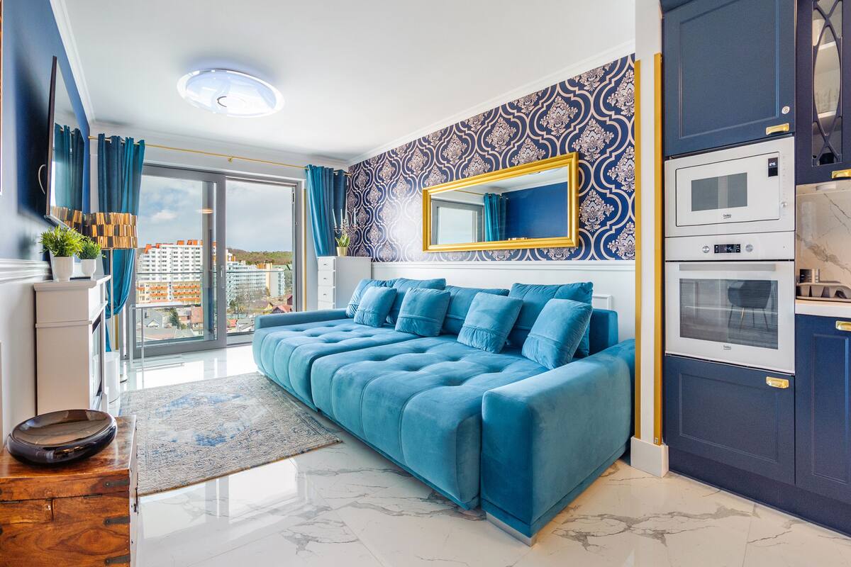 Une chambre moderne avec un grand lit, un téléviseur intégré et une vue sur la ville.