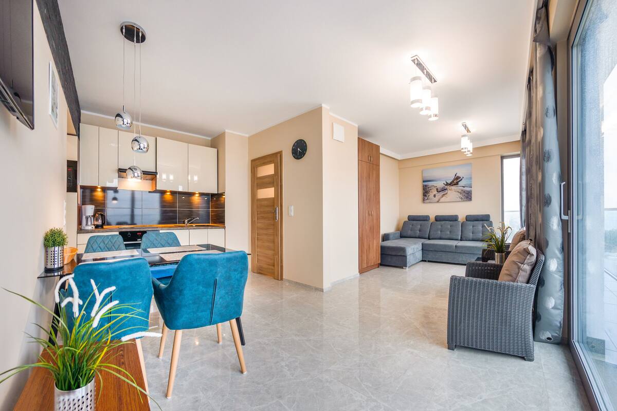 Un espace de vie moderne comprenant un coin repas, une cuisine et un salon avec vue.