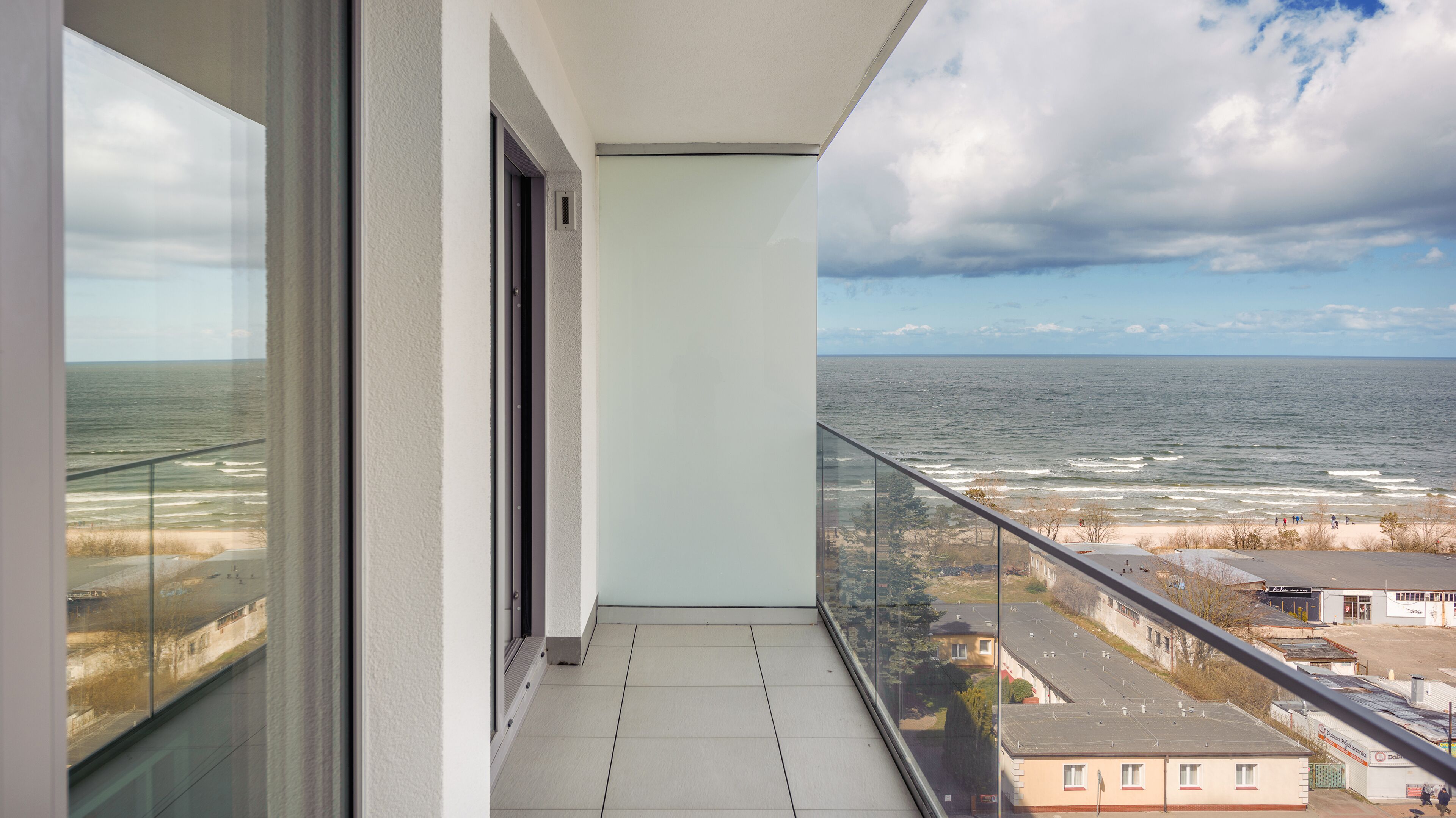 A balcony with a view of the ocean and beach.