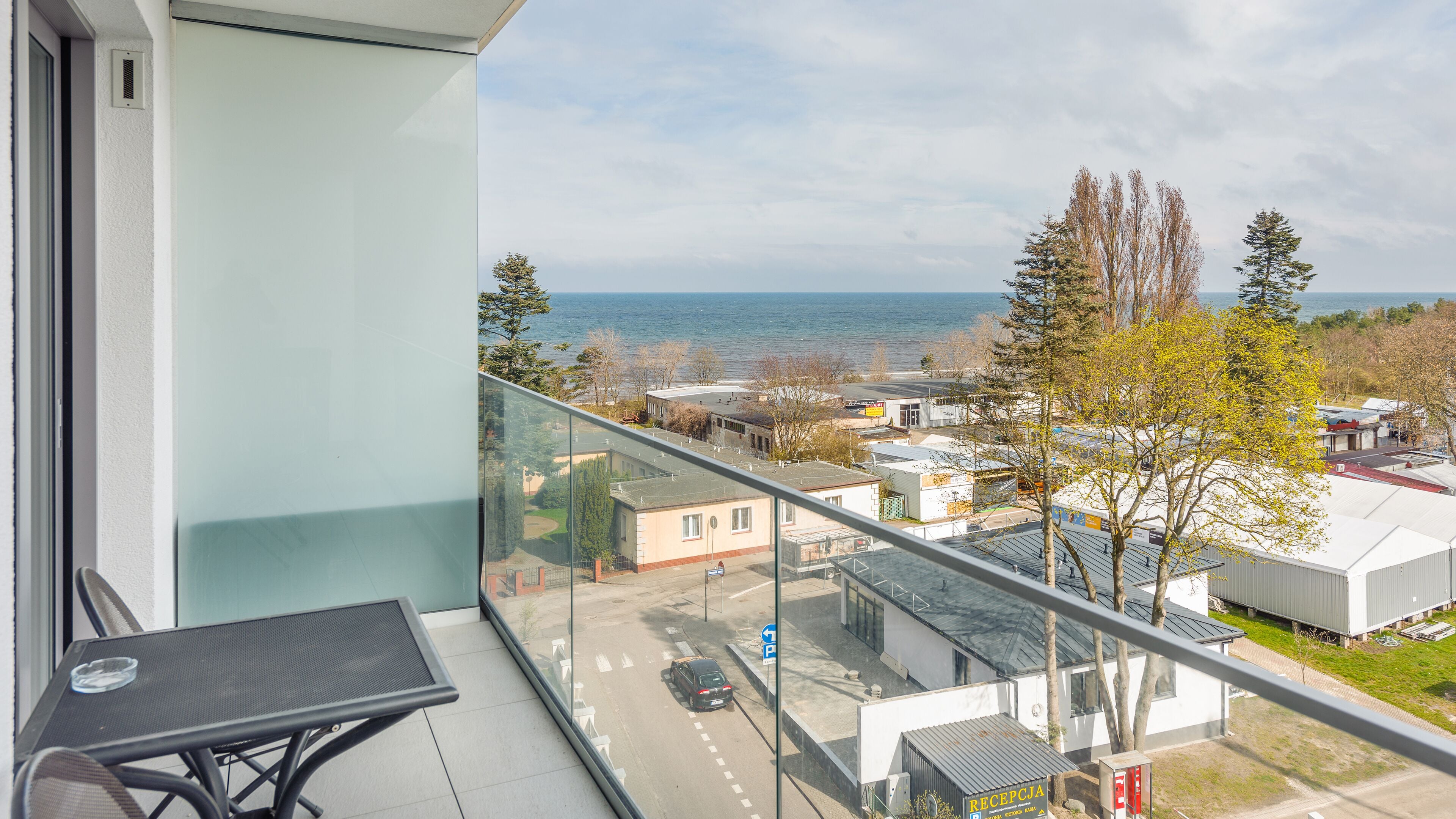Uma varanda com vista clara para o mar e edifícios circundantes.