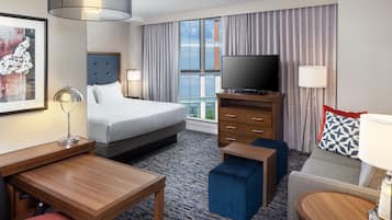 Een hotelkamer met een bed, een bureau, een televisie en een raam met gordijnen.