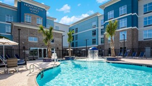Ein Hotelpool mit Liegestühlen und Palmen.