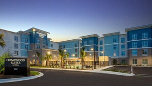A multi-story hotel with a sign indicating 'Homewood Suites by Hilton' and a well-lit entrance area with palm trees. - Homewood Suites by Hilton Myrtle Beach Coastal Grand Mall (Myrtle Beach)
