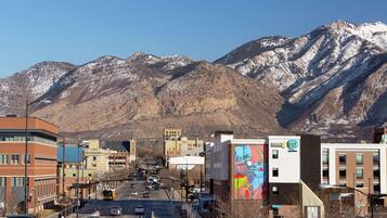 A street with buildings and a mountain in the background.
