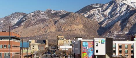 A street with buildings and a mountain in the background.