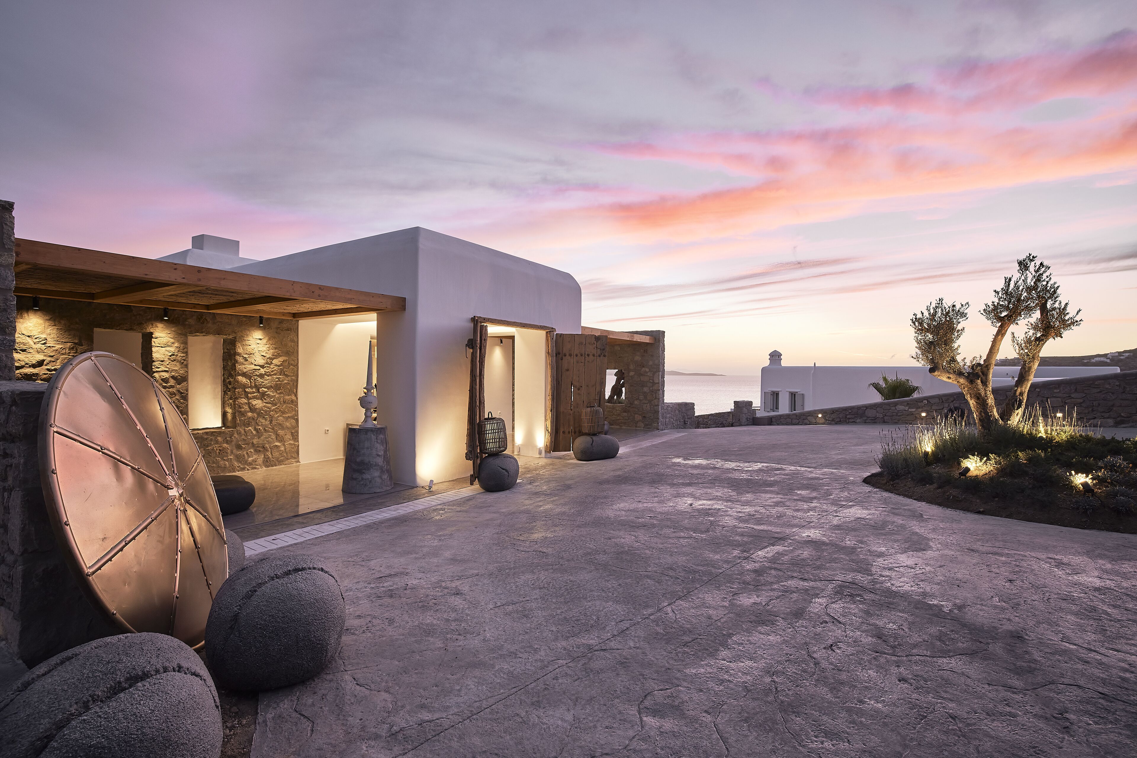 Un edificio moderno con fachada de piedra, ventanas amplias y una entrada bien iluminada.