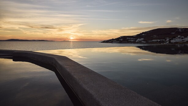 Une étendue d'eau calme qui reflète le ciel au coucher du soleil.