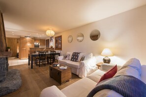 A cozy living room with a sofa, a coffee table, and a dining area with chairs and a table.